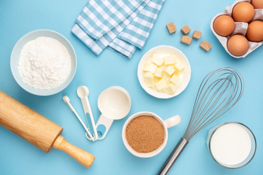 Various baking ingredients and tools on a blue background