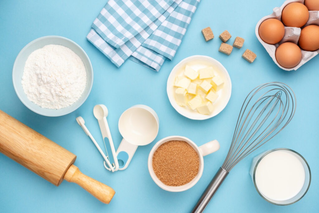 Various baking ingredients and tools on a blue background 