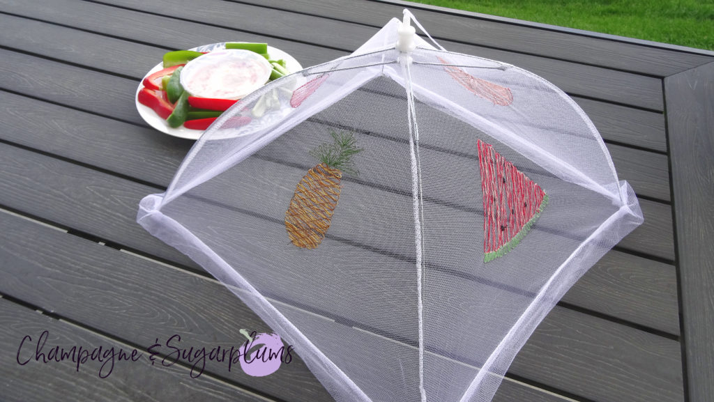 A summer food tent with embroidered fruits on a picnic table by Champagne and Sugarplums