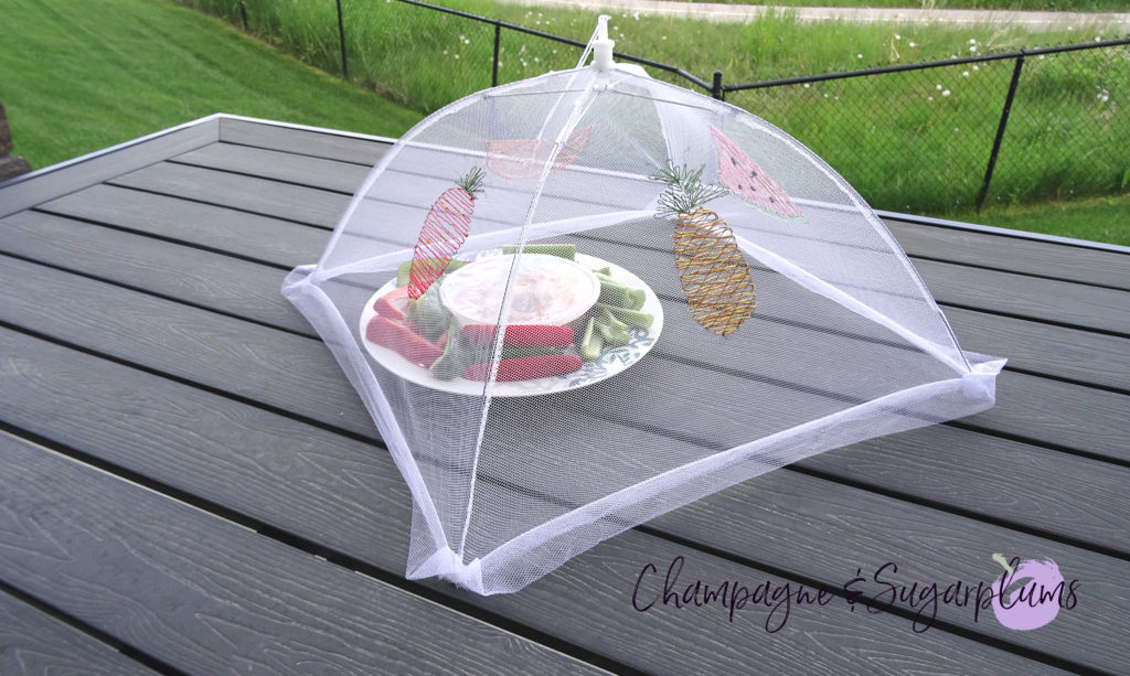 A summer food tent with embroidered fruits on a picnic table by Champagne and Sugarplums
