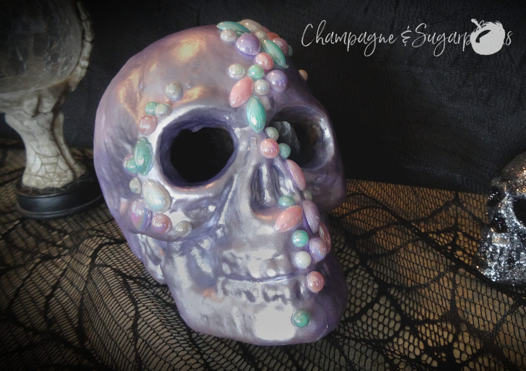 Completed jeweled skull on a black lace background by Champagne and Sugarplums 
