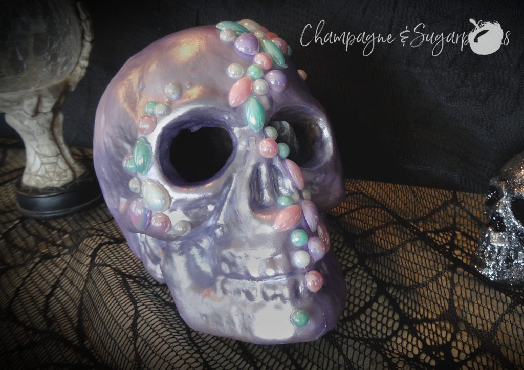 Completed jeweled skull on a black lace background by Champagne and Sugarplums