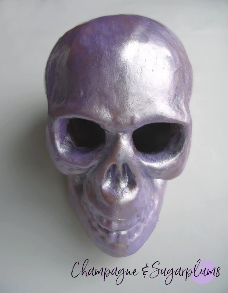 A skull painted lilac on a white background by Champagne and Sugarplums 