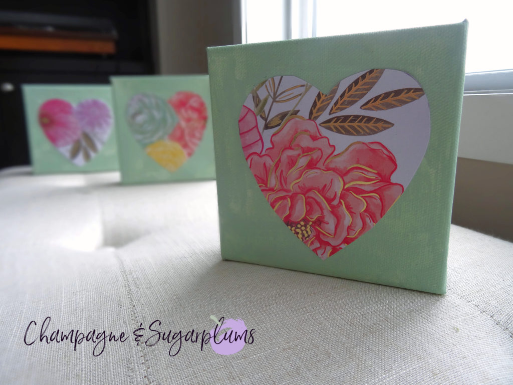 Three completed floral triptych canvases with paper hearts by a window by Champagne and Sugarplums