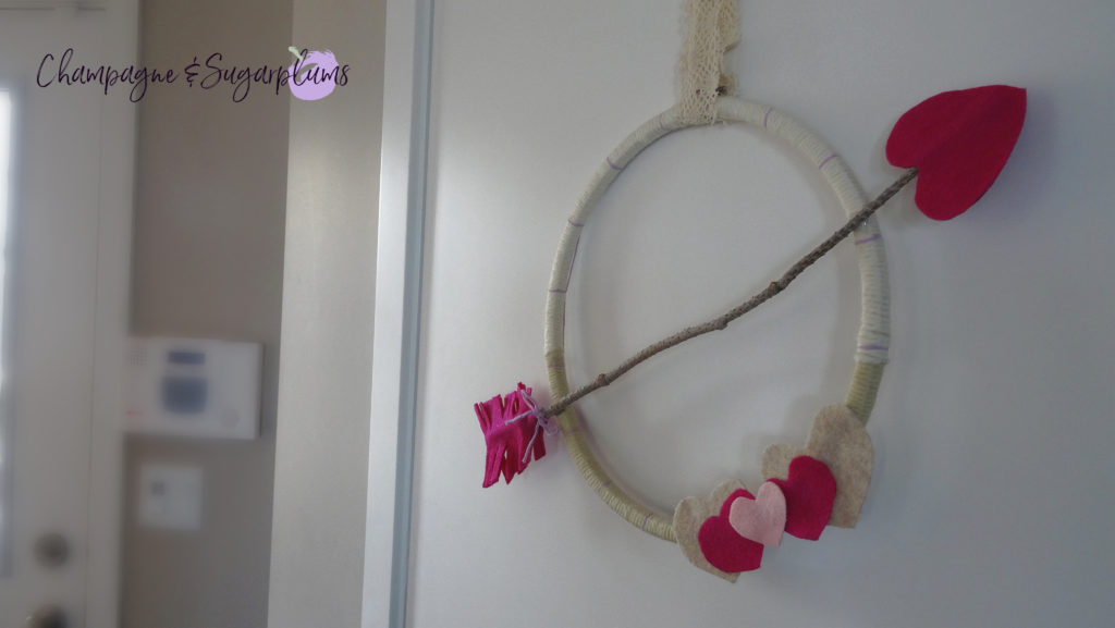 Completed Valentine's Day Wreath hanging on a door by Champagne and Sugarplums