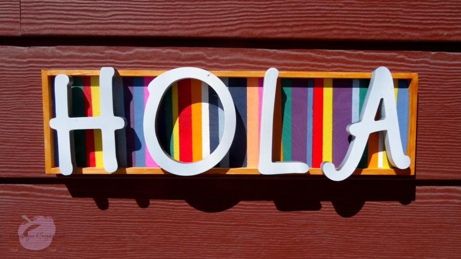 Close up of finished welcome sign hanging on a red wall by Champagne and Sugarplums