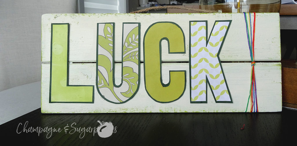 Completed lucky signboard with rainbow threads on a dark background by Champagne and Sugarplums