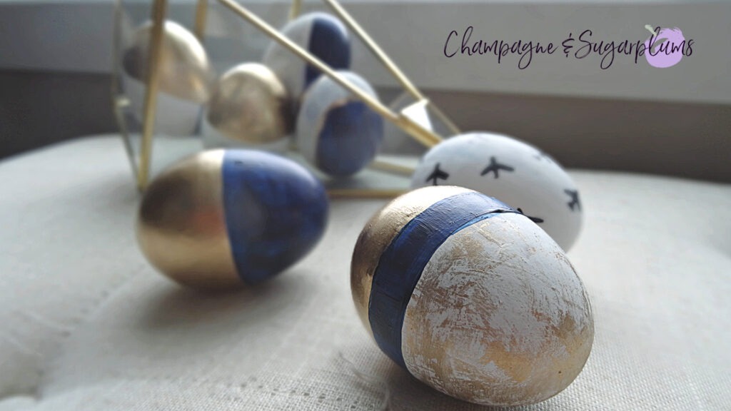 Gold and blue patterned Easter eggs in a terrarium and on a bench by Champagne and Sugarplums