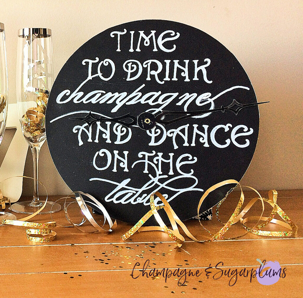 Countdown clock on a table with champagne glasses, ribbon and glitter by Champagne and Sugarplums