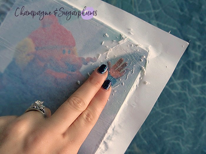 Fingers rubbing to remove photo paper from wood block, leaving image behind by Champagne and Sugarplums