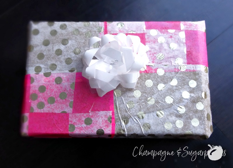 A gift wrapped in pink and gold polka dot patterned holiday wrapping paper  by Champagne and Sugarplums