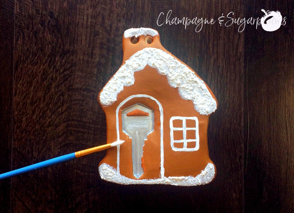 Painting a gingerbread house ornament brown with white embellishments by Champagne and Sugarplums