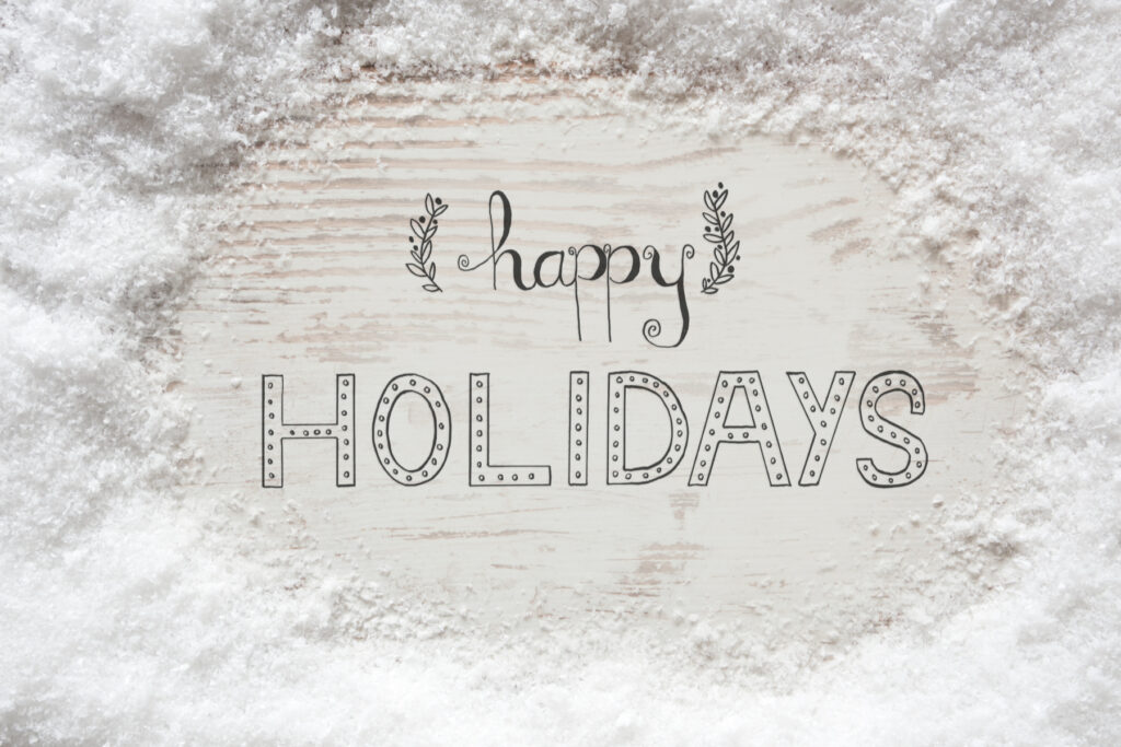 'Happy Holidays' written on a white background surrounded by snow
