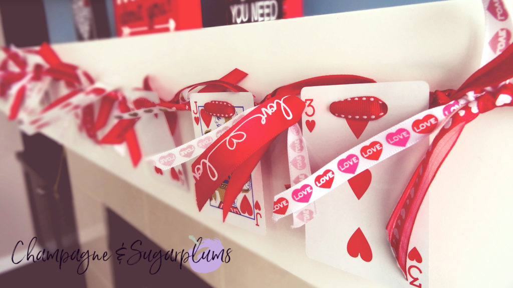 Heart cards garland hanging on a mantel by Champagne and Sugarplums