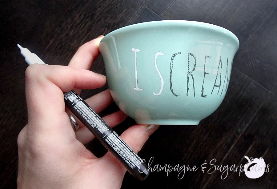 Painting white letters onto Ice Scream bowls on a dark background by Champagne and Sugarplums