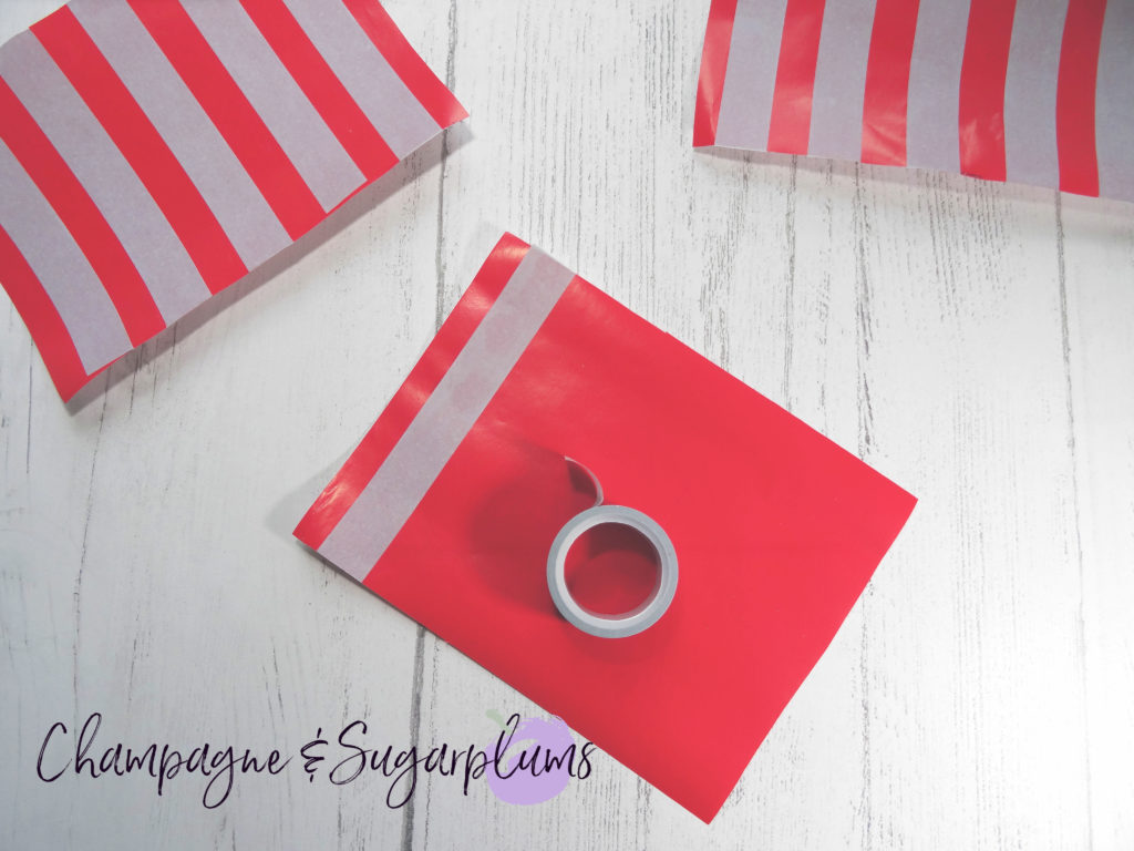 Adding tape stripes to red paper by Champagne and Sugarplums