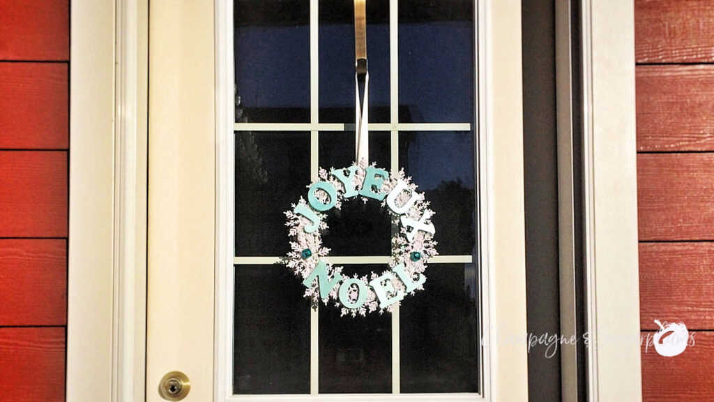 Snowflake wreath hanging on a windowed door by Champagne and Sugarplums