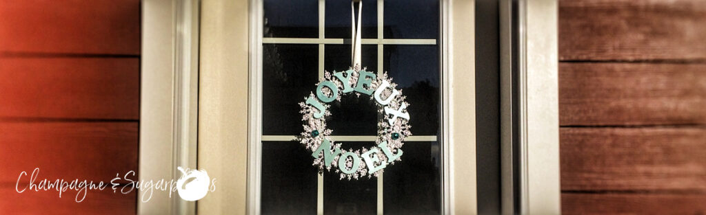 Snowflake wreath hanging on a windowed door by Champagne and Sugarplums