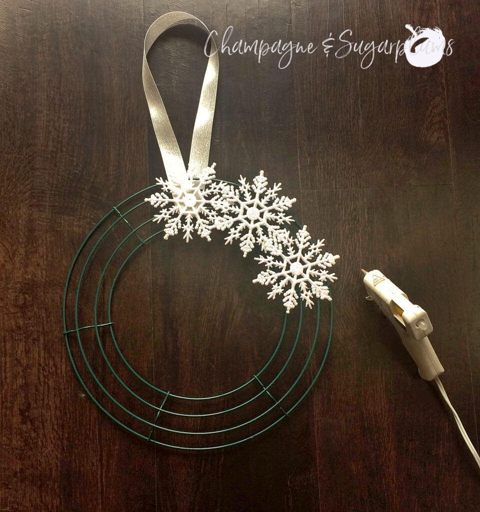 Gluing snowflakes to wire wreath form by Champagne and Sugarplums