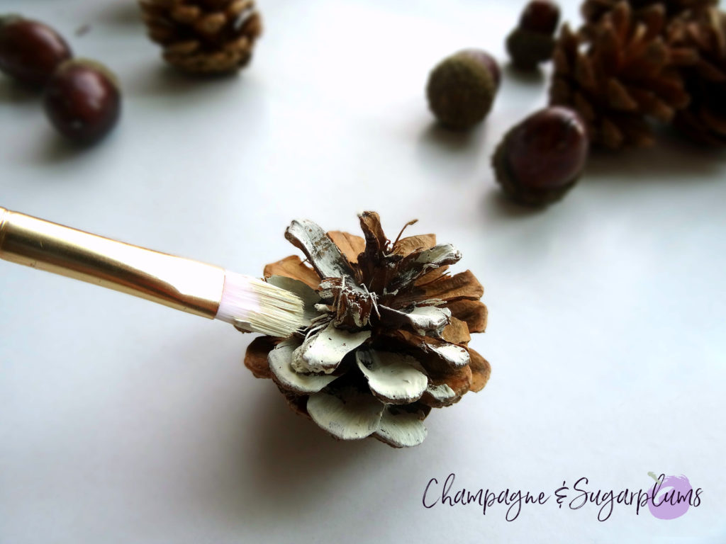 Pinecone being painted cream by Champagne and Sugarplums