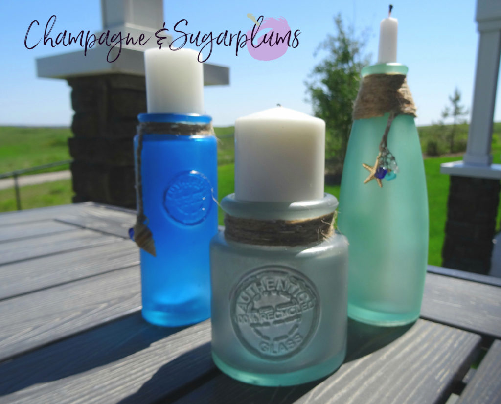 Sea glass bottles on a table outside on a sunny day by Champagne and Sugarplums