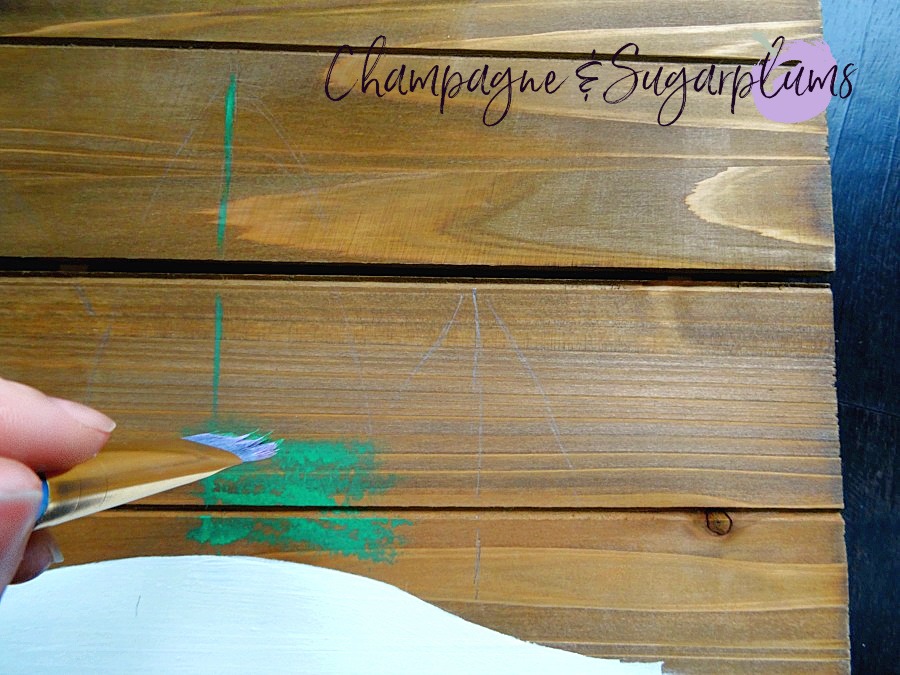 Painting green branches onto wood planks by Champagne and Sugarplums