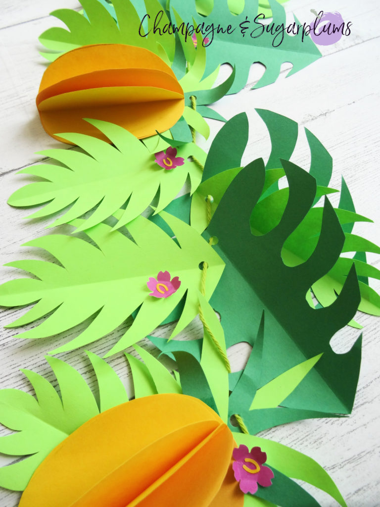 Tropical party decor garland on a white wall by Champagne and Sugarplums