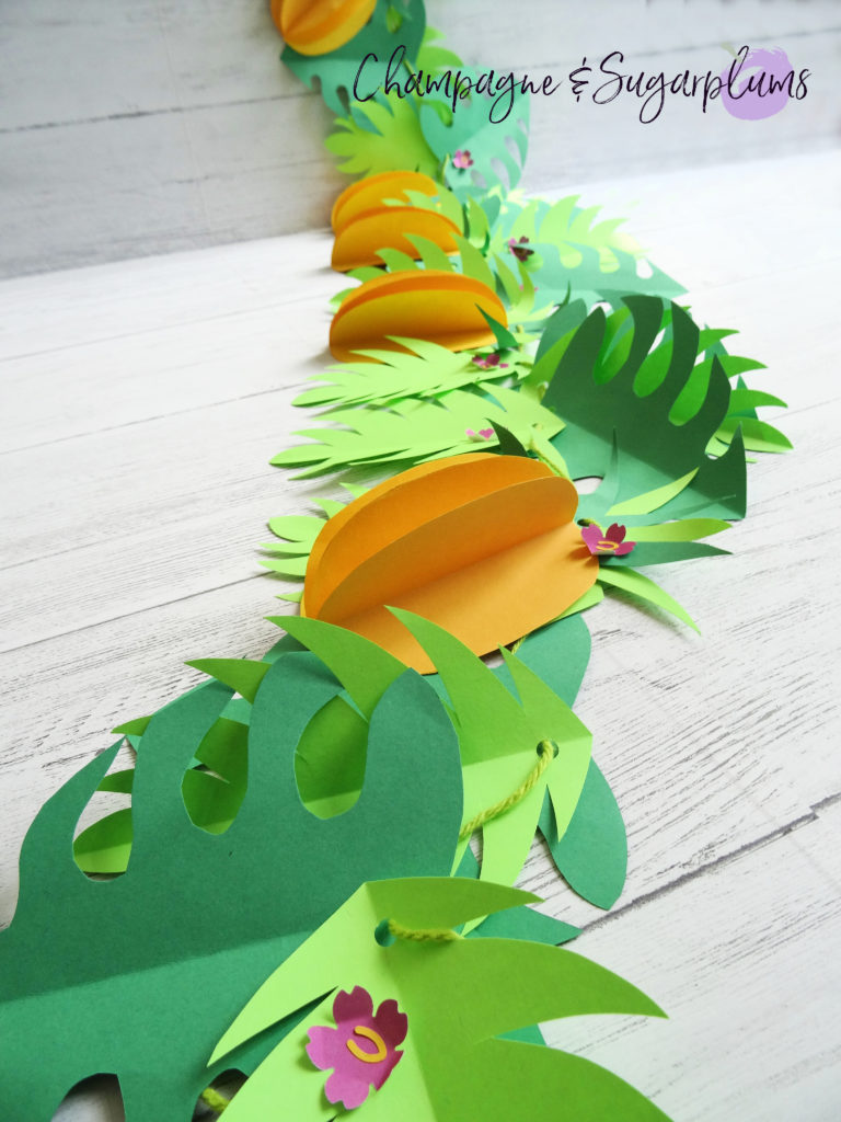 Tropical party decor garland on a white wall by Champagne and Sugarplums