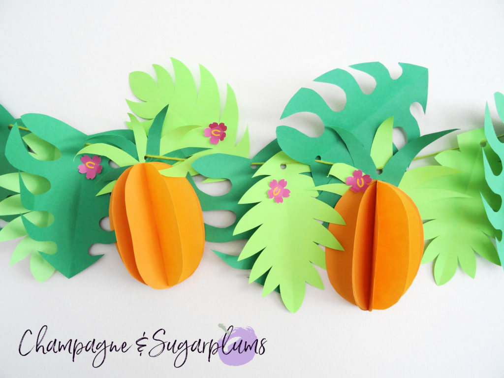 Tropical party decor garland on a white wall by Champagne and Sugarplums