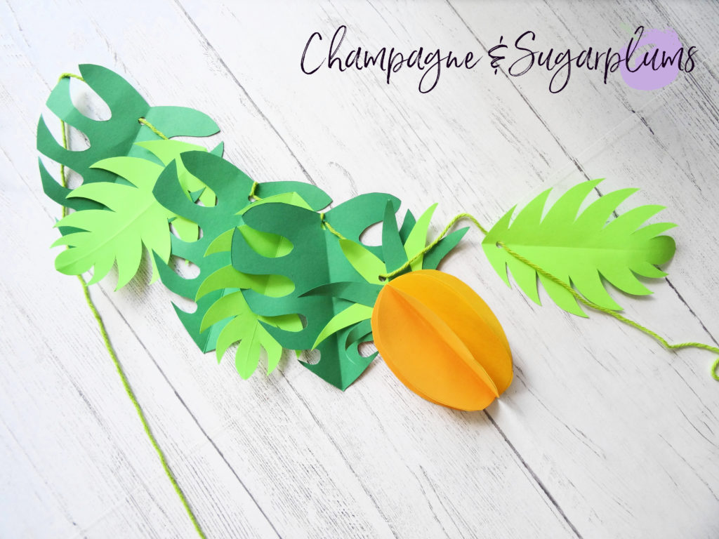 Stringing paper leaves and pineapples onto yarn by Champagne and Sugarplums