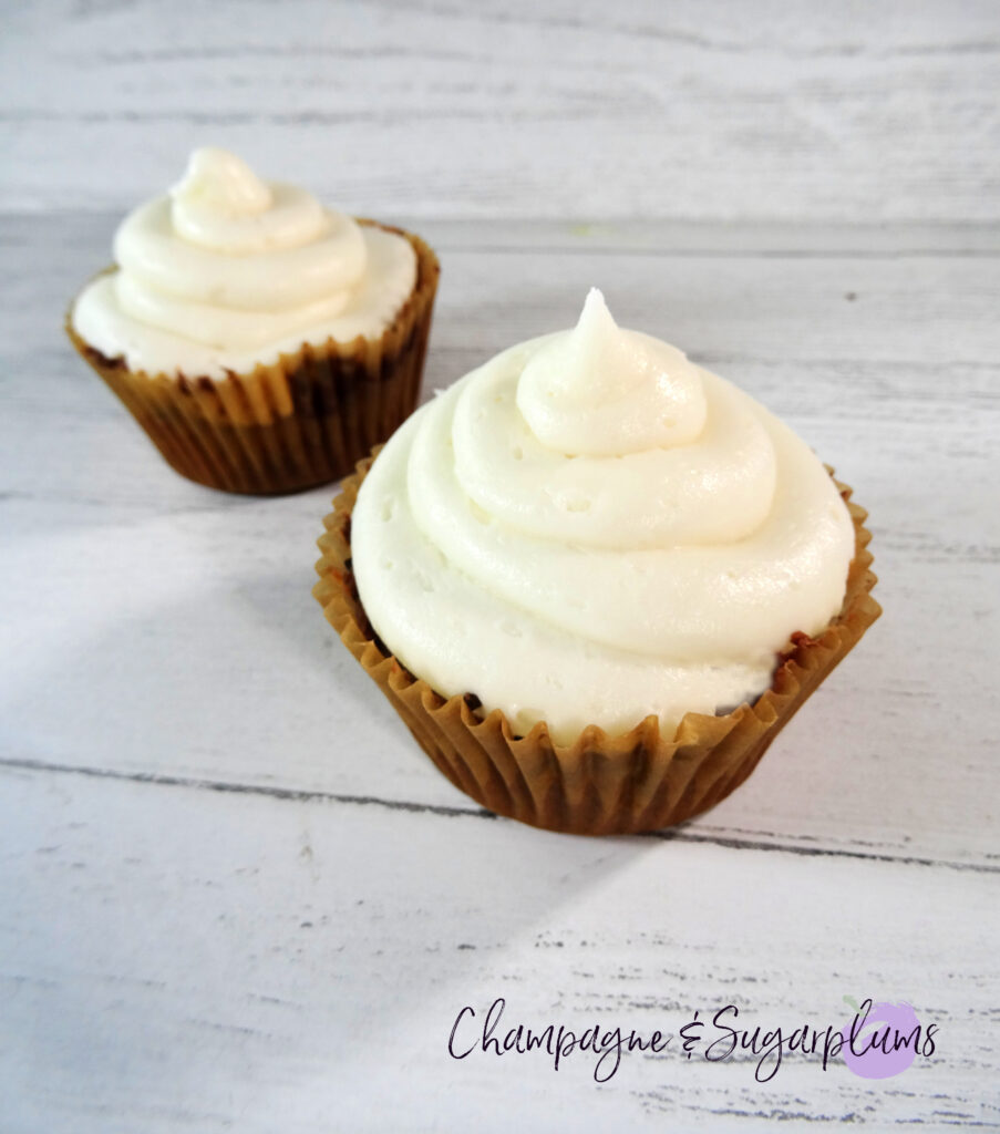 Pumpkin Cupcakes with white icing on a white background by Champagne and Sugarplums