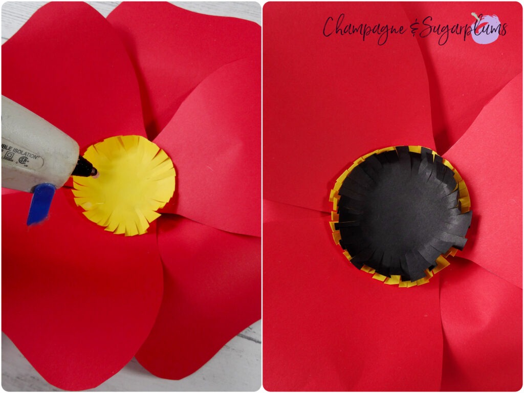 Gluing first a yellow and then a black paper circle to the centre of red paper flower by Champagne and Sugarplums