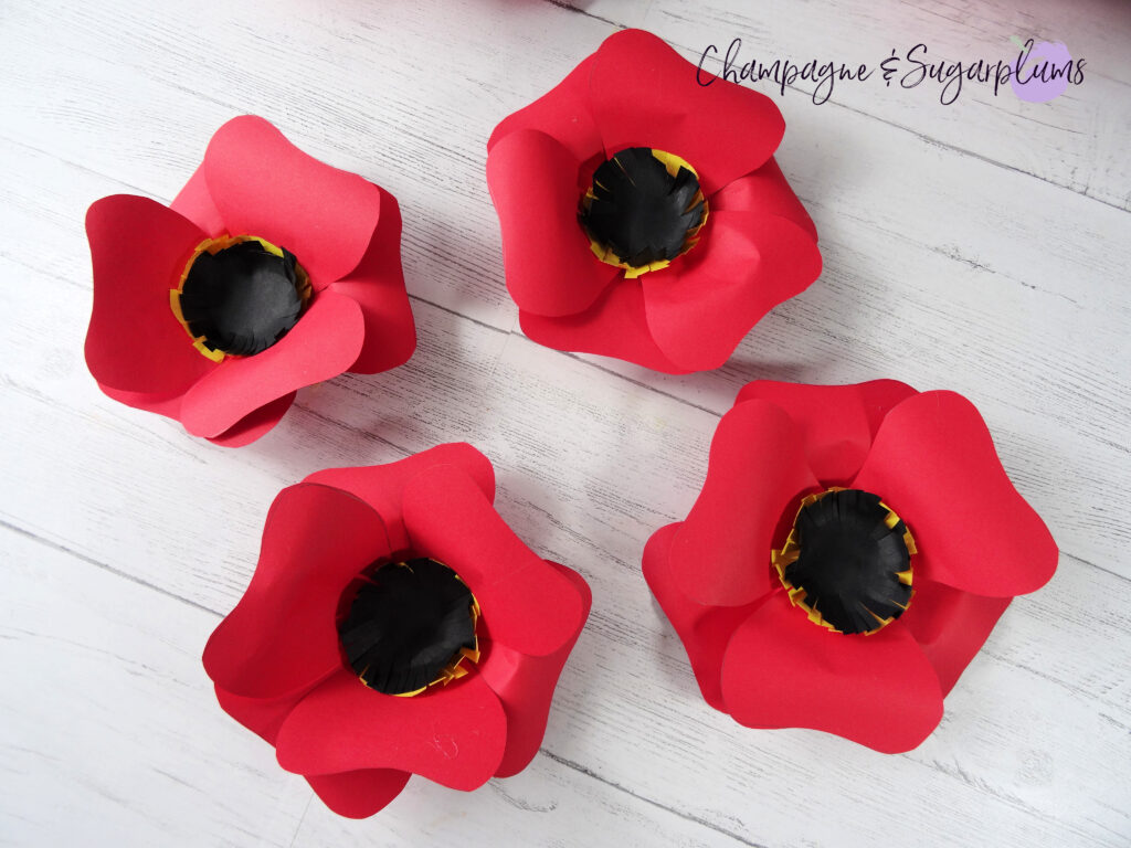 Four completed medium sized red paper flowers by Champagne and Sugarplums