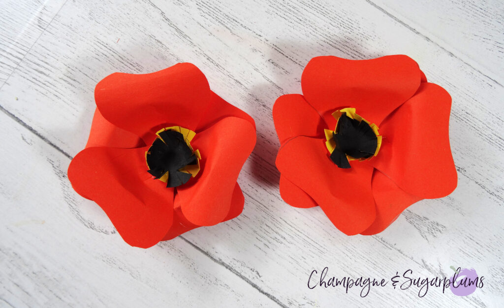 Two completed small sized orange paper flowers by Champagne and Sugarplums