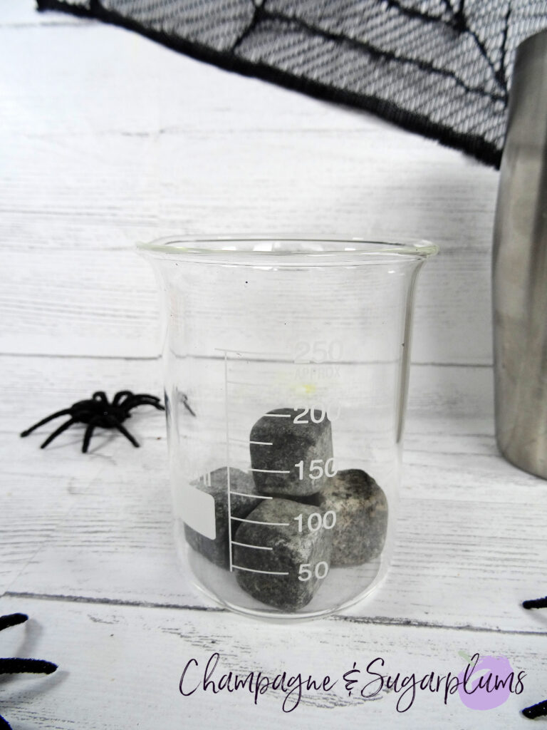 Adding ice stones to a Halloween beaker by Champagne and Sugarplums