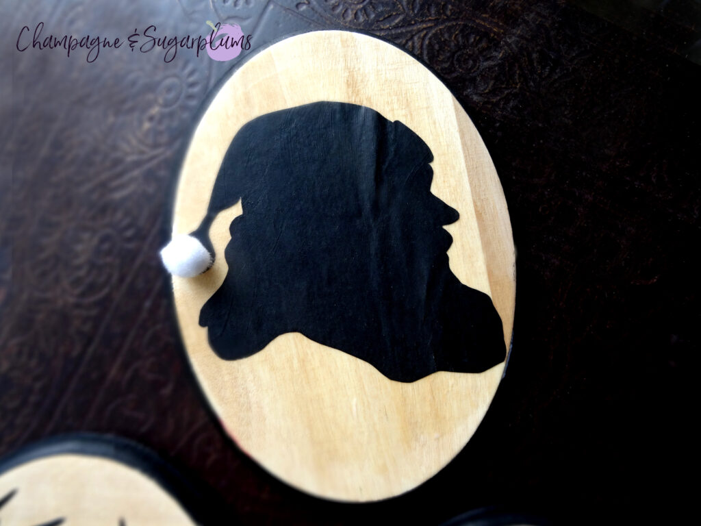 Santa silhouette on a wood board on a dark background by Champagne and Sugarplums