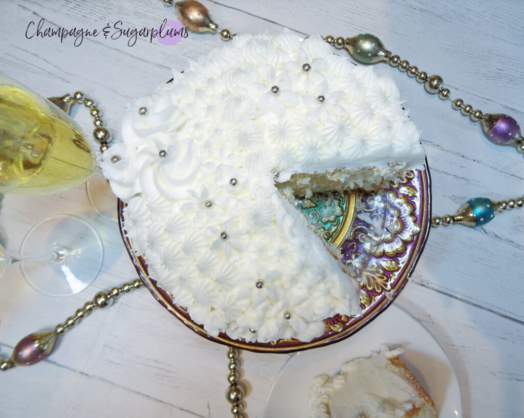 Champagne Cake on a decorative stand with champagne flutes and garland by Champagne and Sugarplums