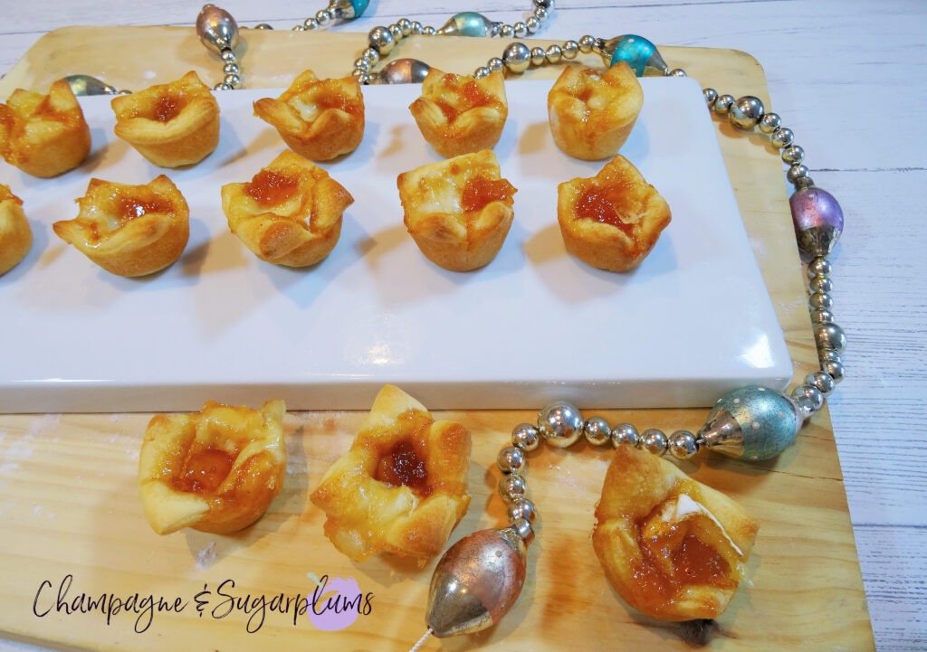Mango Brie Bites on a white plate with glass garland by Champagne and Sugarplums