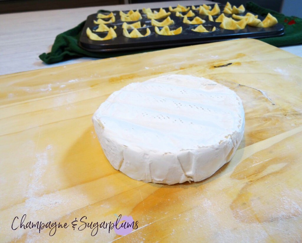 Circle of Brie on a wood board by Champagne and Sugarplums