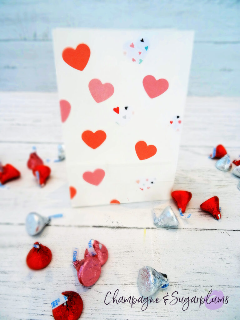 Valentine Treat Bags with pink hearts on white background surrounded by chocolates by Champagne and Sugarplums