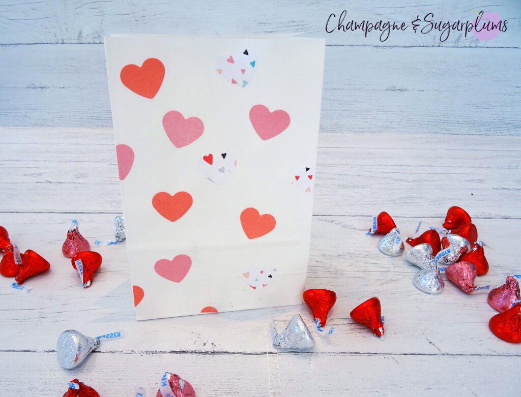 Valentine Treat Bags with pink hearts on white background surrounded by chocolates by Champagne and Sugarplums