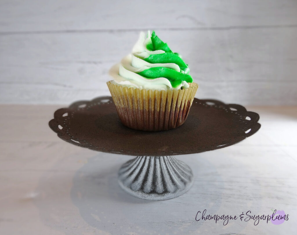 Chocolate cupcake with peppermint frosting on a metal cake stand on a white background by Champagne and Sugarplums