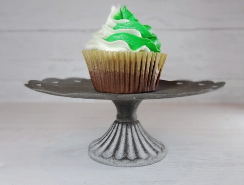 Green and white frosted chocolate cupcake on a metal stand by Champagne and Sugarplums