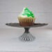 Green and white frosted chocolate cupcake on a metal stand by Champagne and Sugarplums