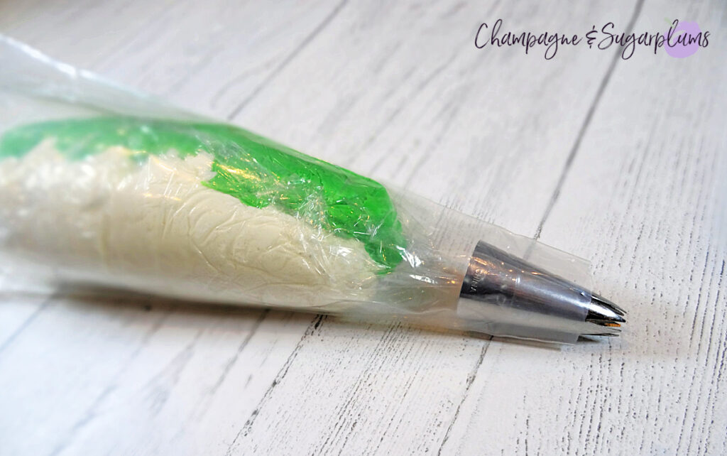 White and green frosting in a piping bag with a star tip on a white background by Champagne and Sugarplums