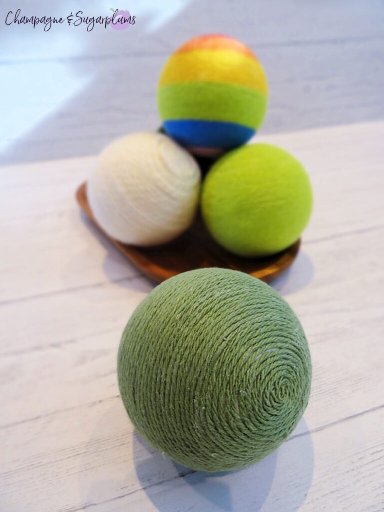 Lucky Green Balls - Styrofoam balls wrapped in varying shades of green on a white background by Champagne and Sugarplums