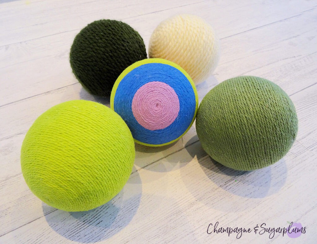 Lucky Green Balls - Styrofoam balls wrapped in varying shades of green on a white background by Champagne and Sugarplums