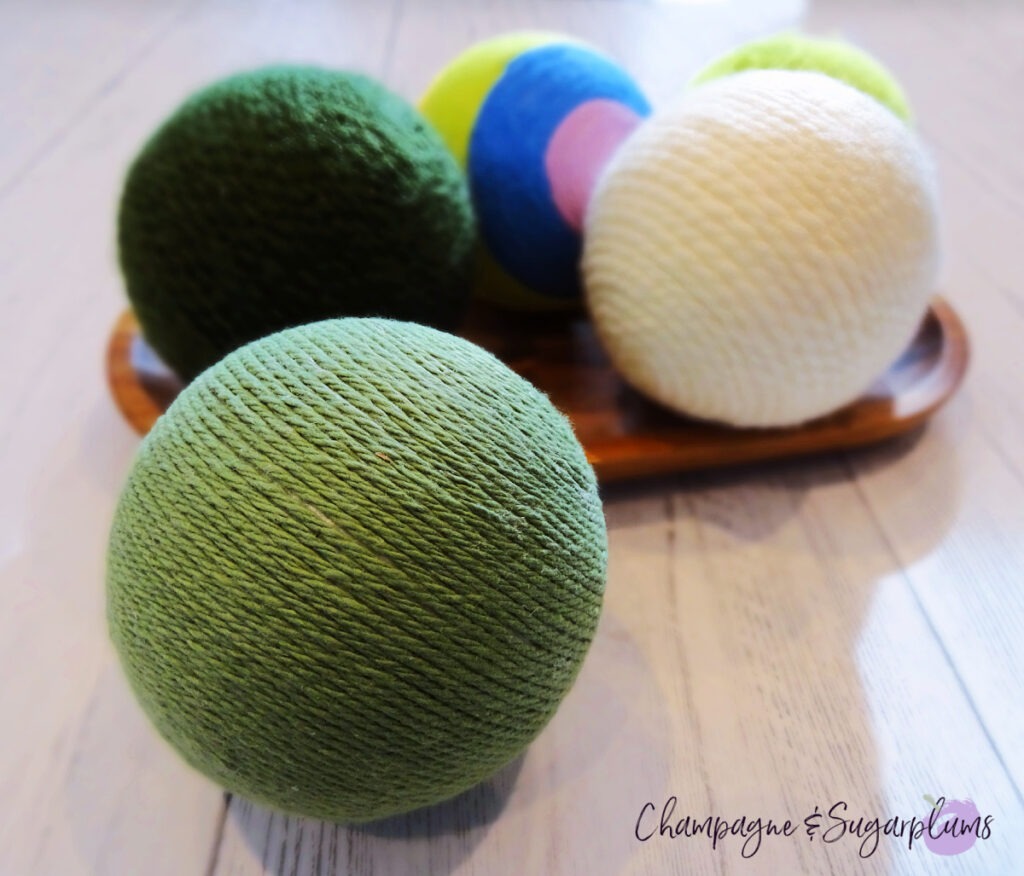 Lucky Green Balls - Styrofoam balls wrapped in varying shades of green on a white background by Champagne and Sugarplums