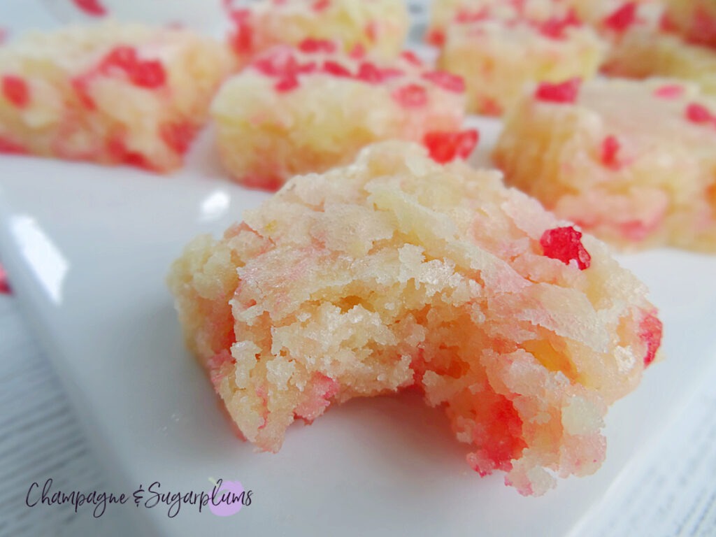 Canada Day Brownies on a white plate with red maple leaf confetti scattered around by Champagne and Sugarplums