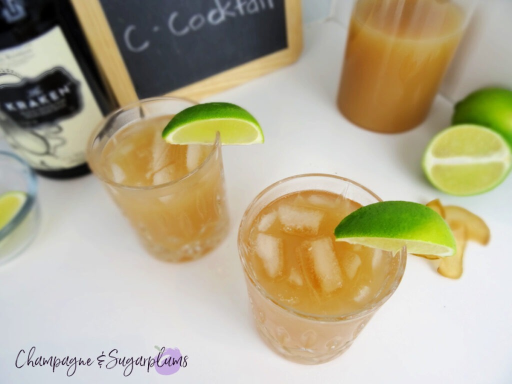 The Teacher's Pet Back to School Cocktail in highball glasses, pictured from above, garnished with lime wedges on a white background with limes and chalkboard by Champagne and Sugarplums